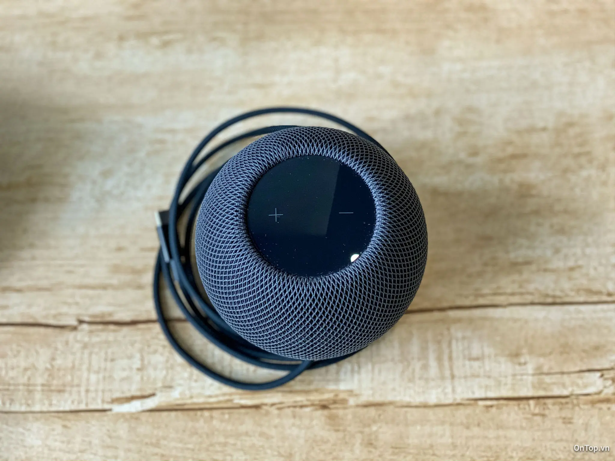 Mặt trên của HomePod mini có hai nút cảm ứng, đèn nền, bề mặt cảm ứng